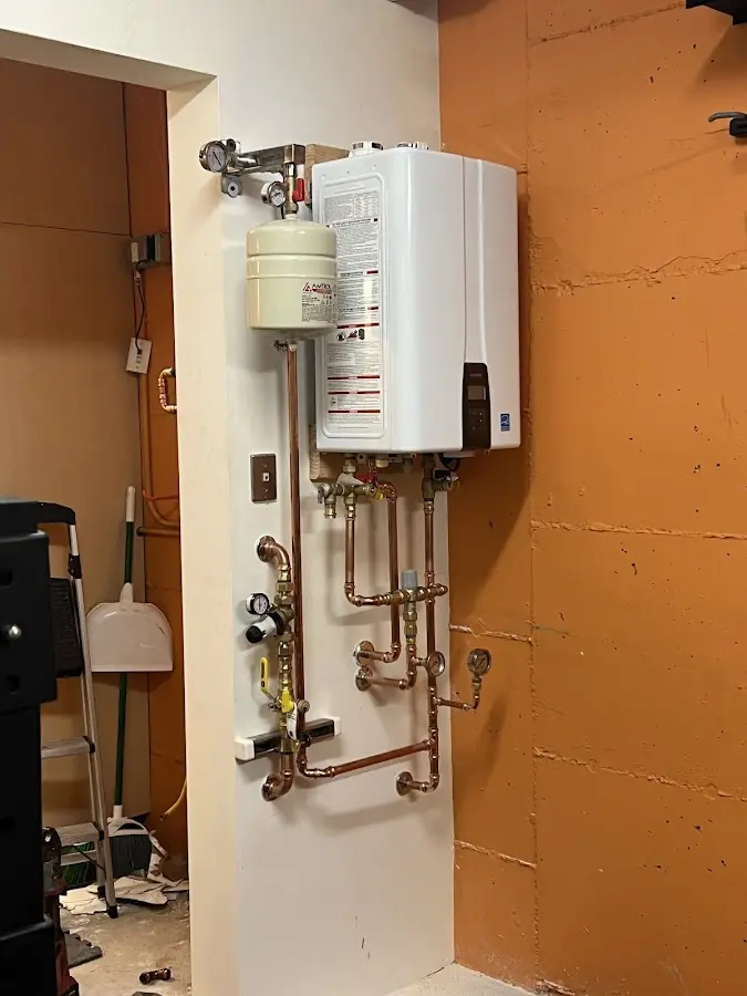 Plumbing technician inspecting water heater connections in Powdersville